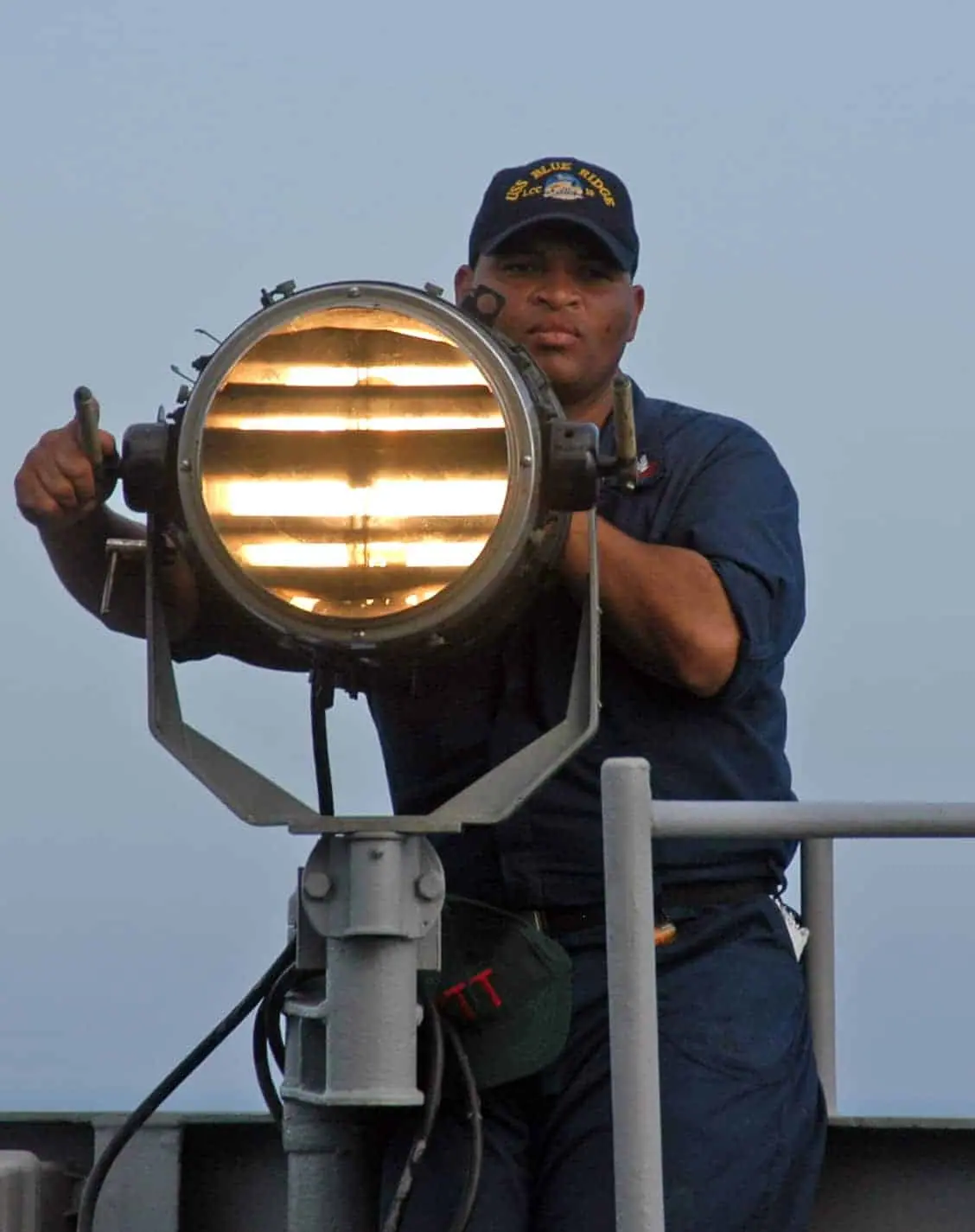 050322-N-9860Y-109 Philippine Sea (Mar. 22, 2005) - Quartermaster 2nd Class Tony Evans of Houston, Texas, sends Morse code signals from the bridge wing aboard the command ship USS Blue Ridge (LCC 19) to the Military Sealift Command (MSC) combat stores ship USNS Concord (T-AFS 5), during a replenishment at sea. Blue Ridge, permanently forward deployed to Yokosuka, Japan, is on a regularly scheduled deployment in the Western Pacific and Indian Oceans. U.S. Navy photo by Photographer's Mate 3rd Class Tucker M. Yates (RELEASED)